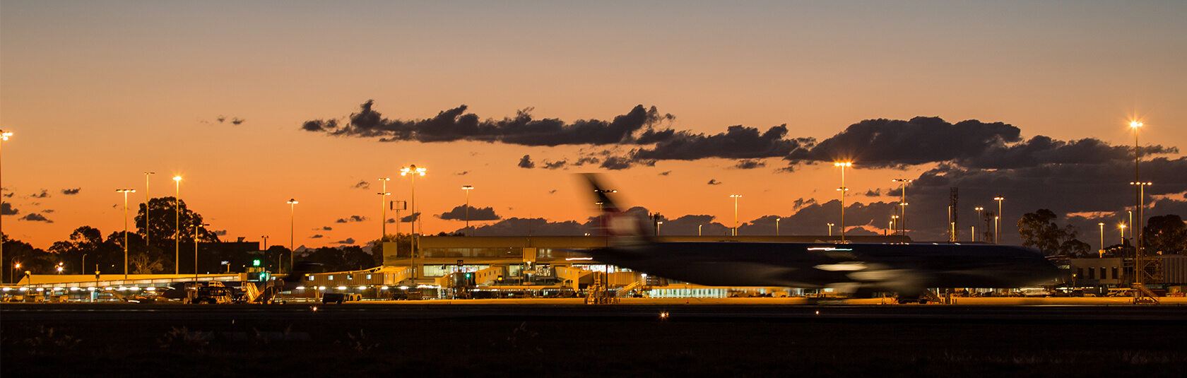 Plane landing with orange sunset in the background