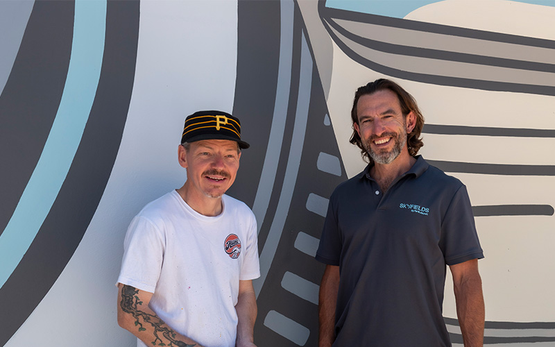 Artist Cale Hummerston and Chief Property Officer Dan Sweet at new mural