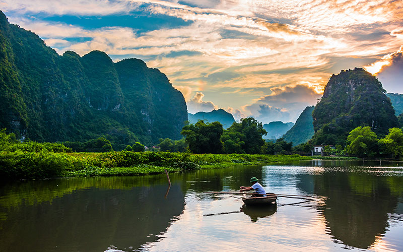 Person rowing through the waters of Trang An