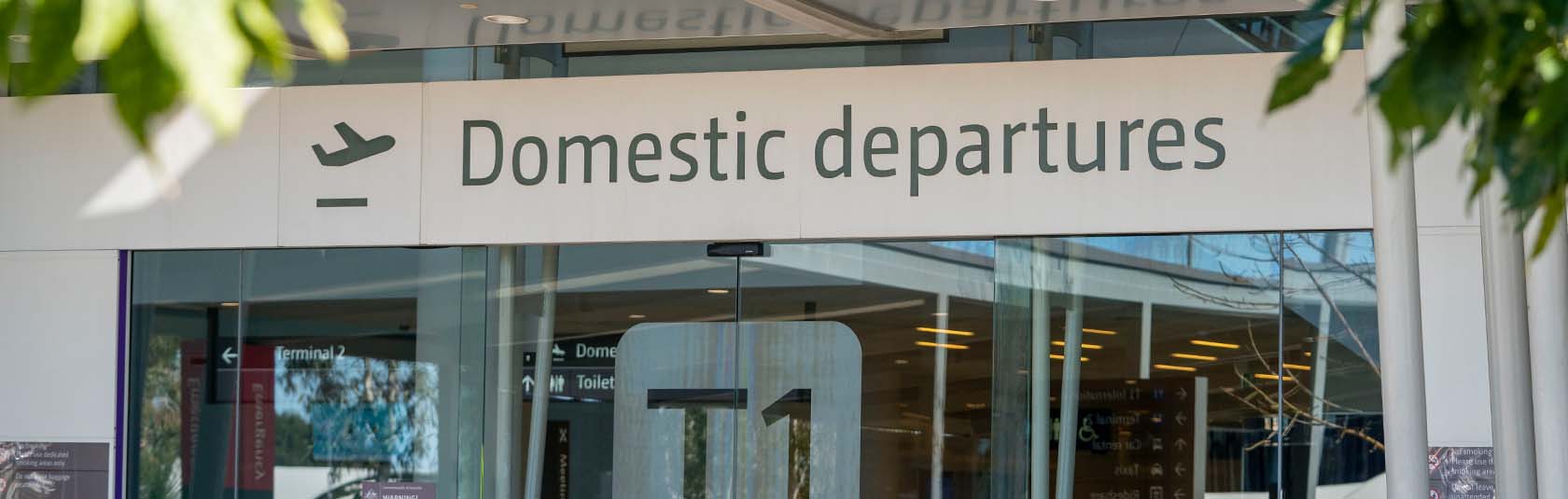Domestic Departures signage above Terminal 1 doors